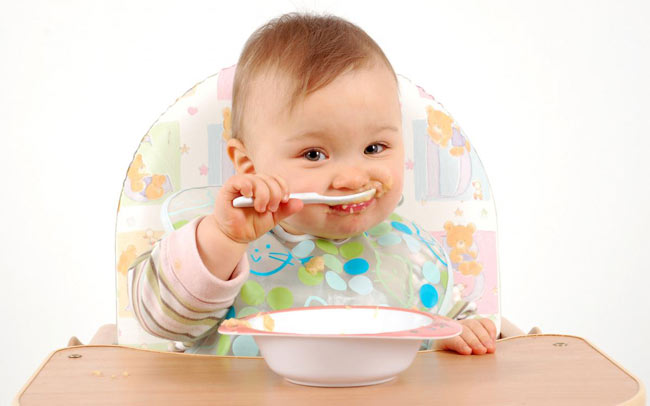 Ребенок ест вкусное грушевое пюре